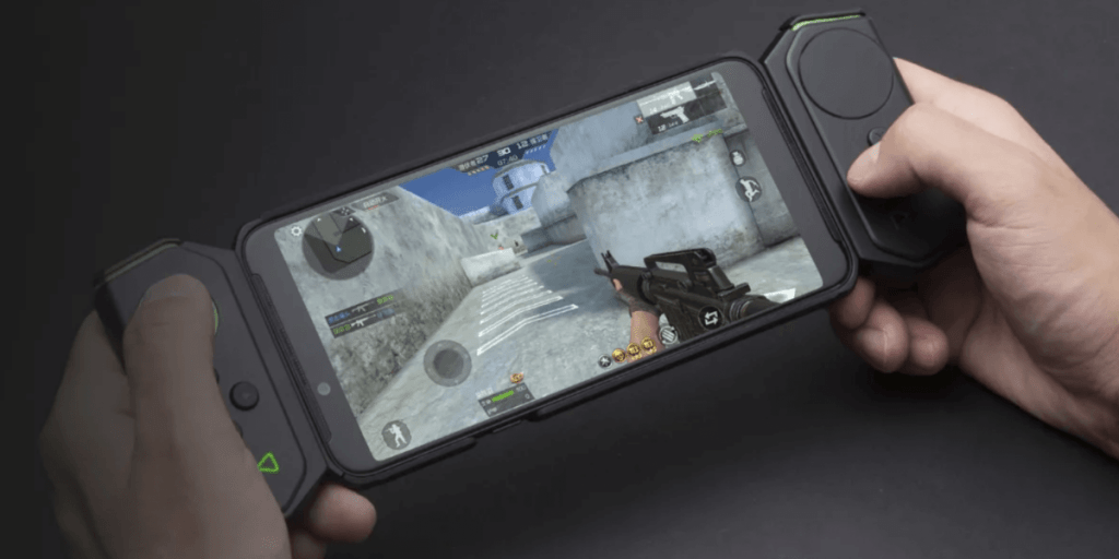 pessoa jogando no celular com um controle para celular.